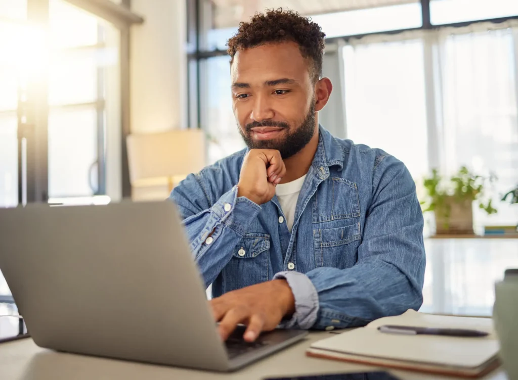 Happy businessman working on his laptop at home.