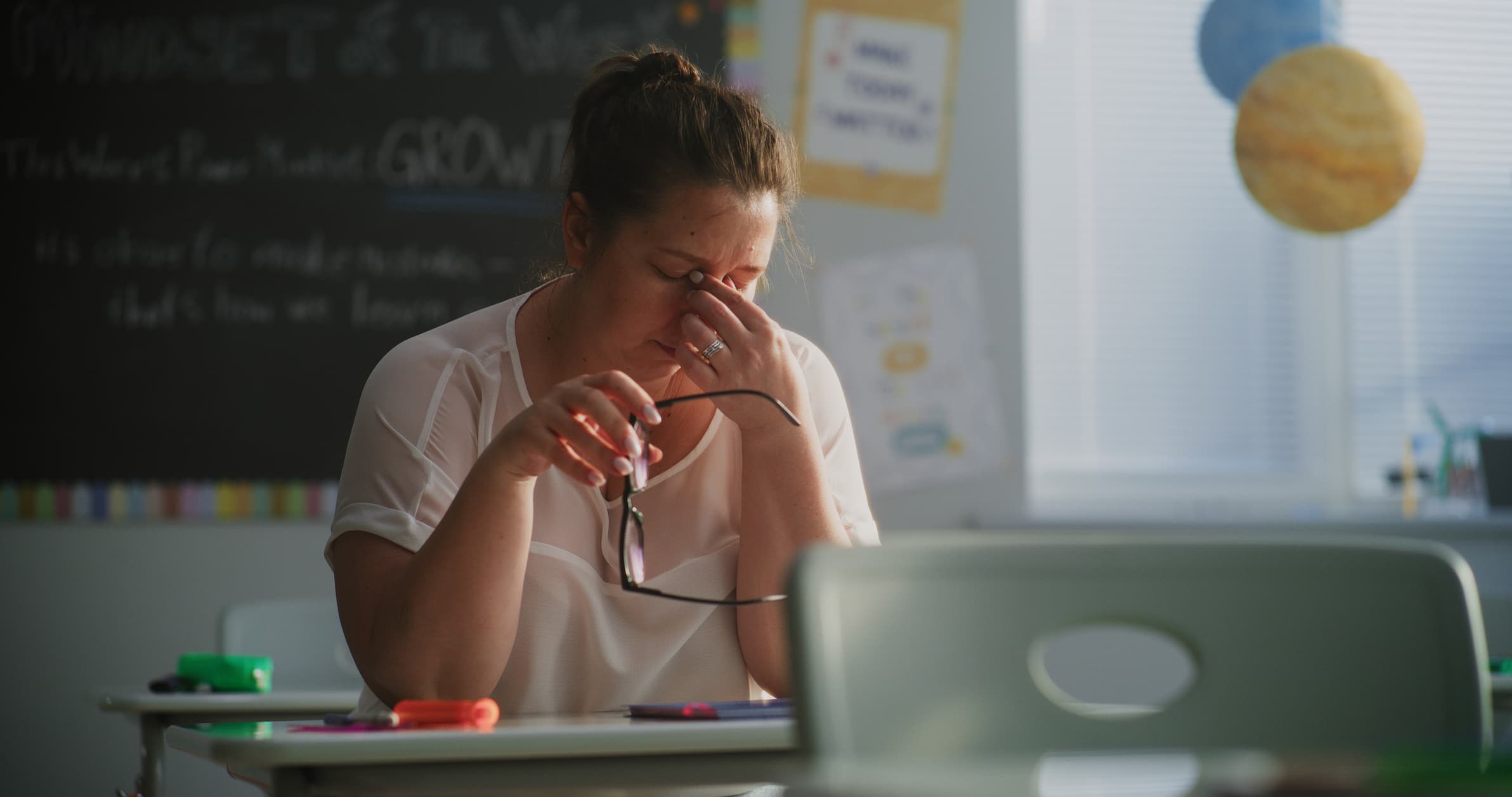 teacher anxiety - a stressed teacher sitting at their desk